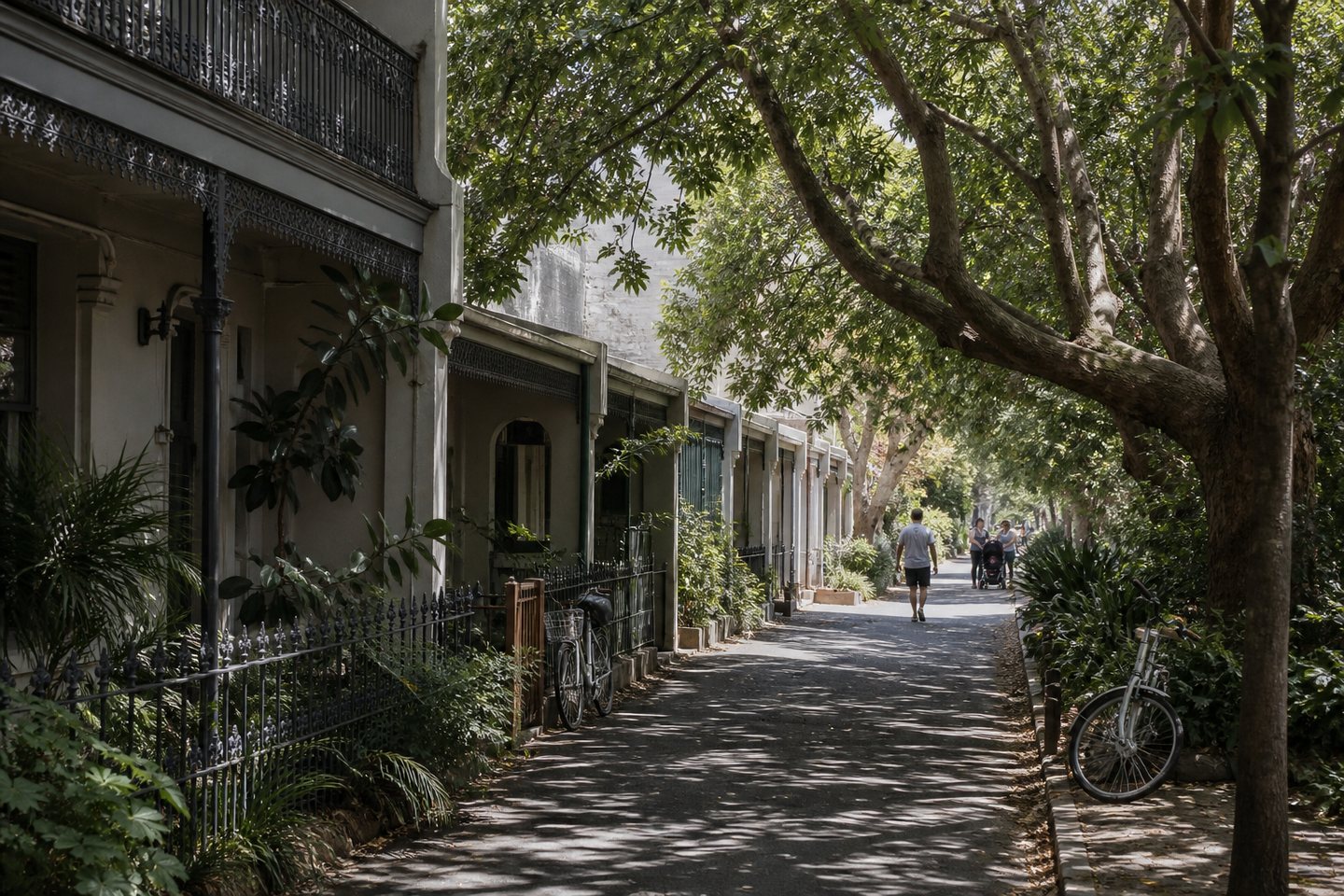 Tree-shaded pedestrian lane lined with Australian terrace homes